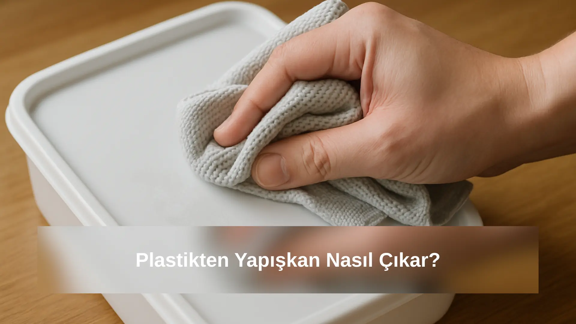 Plastik saklama kabının kapağındaki etiket yapışkanını mikrofiber bezle silen elin yakın plan fotoğrafı