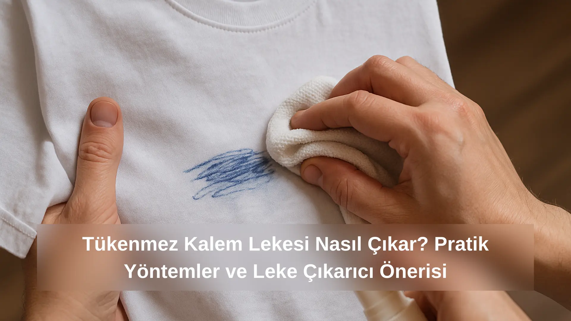 Bir pamuklu bezle beyaz tişörtten tükenmez kalem lekesi silinirken yakın çekim