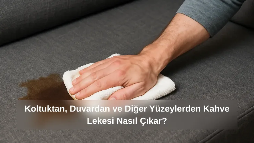 Koyu gri koltuk kumaşı üzerinde kahve lekesini beyaz havluyla nazikçe silen bir el